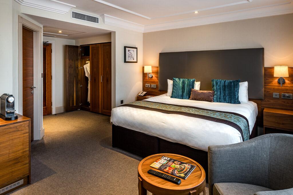 Deluxe king bed and wardrobe - Marble Arch Hotel